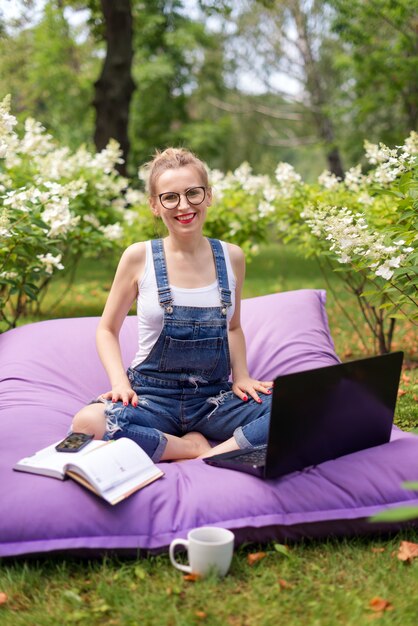 Mulher usando seu laptop no jardim