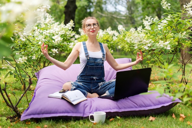 Mulher usando seu laptop no jardim