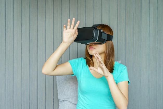 Mulher usando simulador de realidade virtual contra a parede