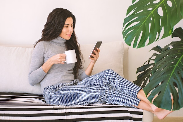 Mulher usando smartphone em casa