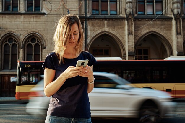 Mulher usando smartphone na rua da cidade