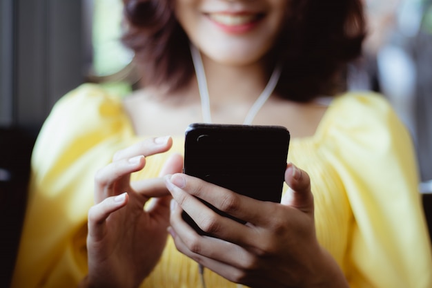 Foto mulher usando smartphone ouvindo música no tempo livre com feliz.