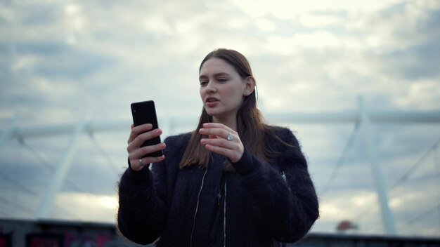 Mulher usando smartphone para videochamada Garota conversando com um amigo por bate-papo por vídeo