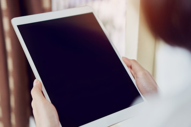 Mulher usando tablet de tela em branco. tela em branco para os gráficos. conceitos para techn digital