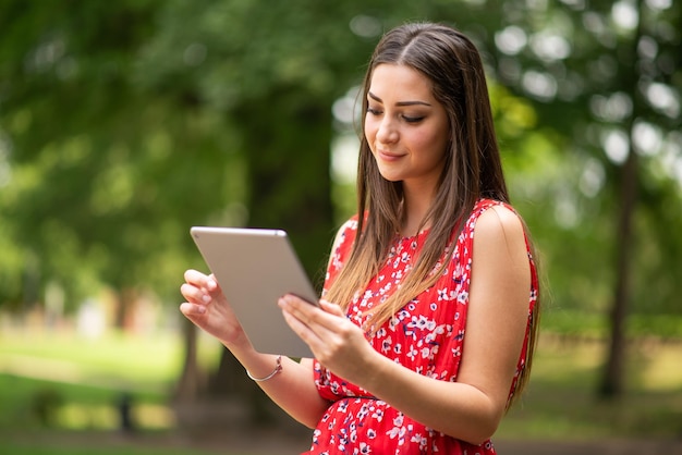 Mulher usando tablet digital no parque
