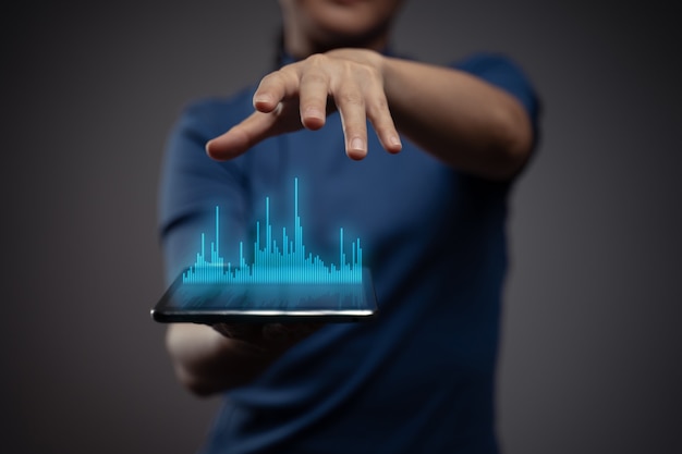 Mulher usando tablet, planejando marketing digital com efeito de holograma gráfico