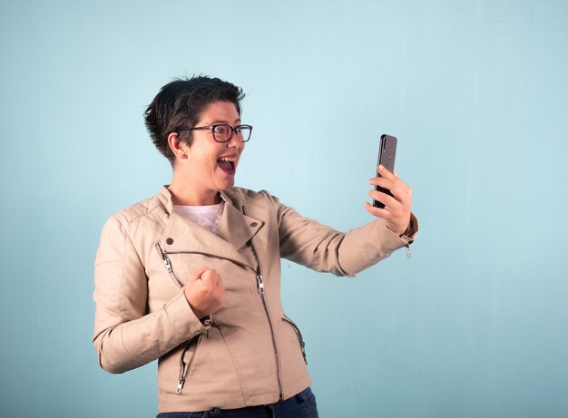 Mulher usando telefone celular contra fundo azul