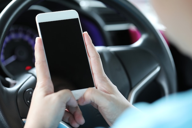 Mulher usando telefone celular no carro.