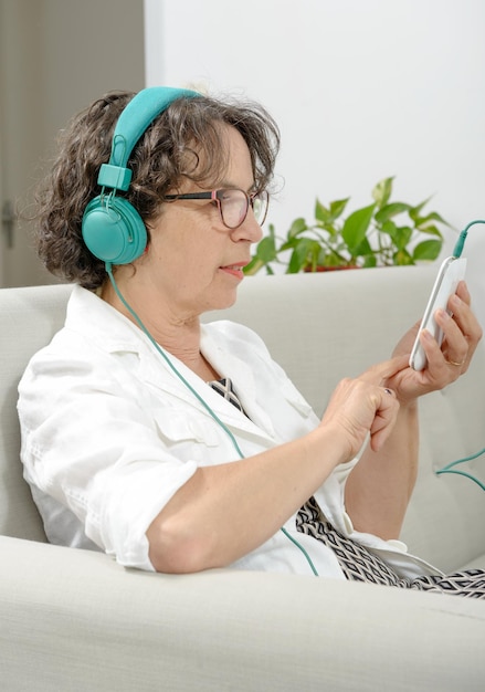Mulher usando telefone celular no sofá em casa