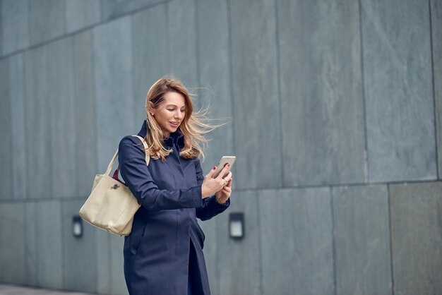Mulher usando telefone junto à parede