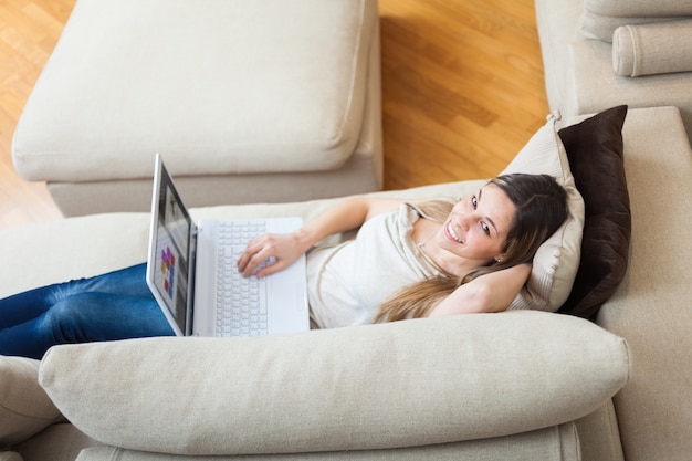 Mulher usando um laptop em sua casa