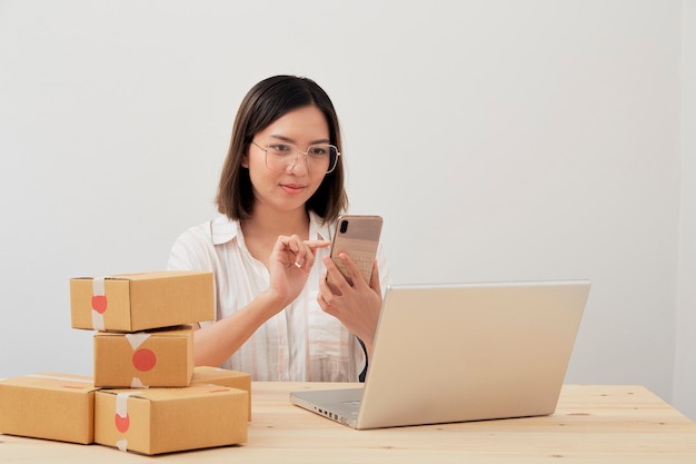 Mulher usando um smartphone e laptop