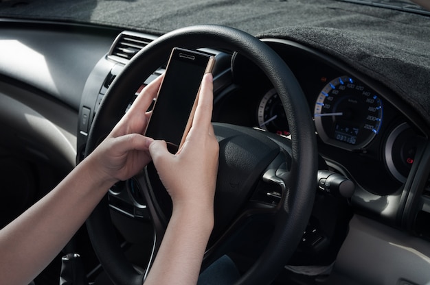Mulher usando um smartphone enquanto dirigia um carro. dependência de mídia social