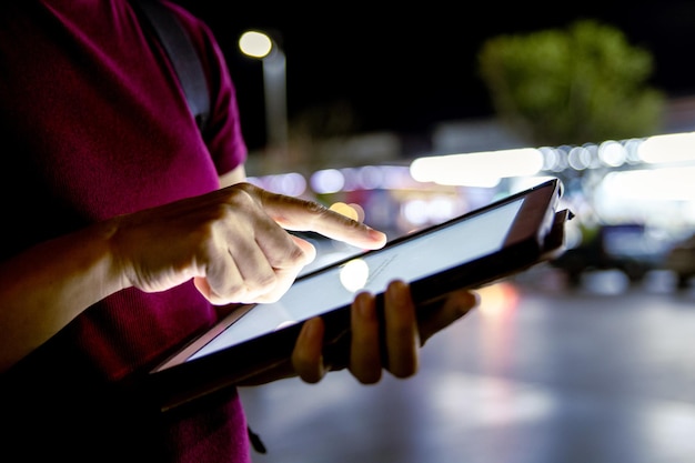 Mulher usando um tablet à noite na cidade