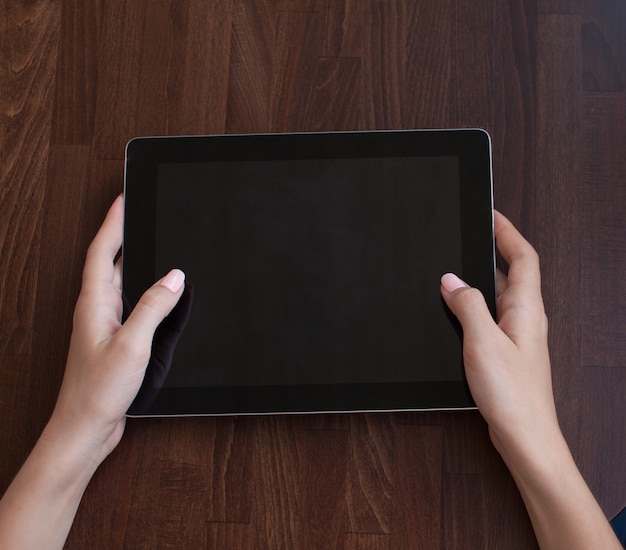 Mulher usando um tablet com tela de toque com as mãos fechadas