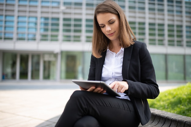Mulher usando um tablet na frente de seu escritório