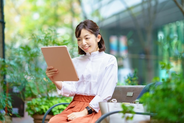 Mulher usando um tablet PC no espaço verde