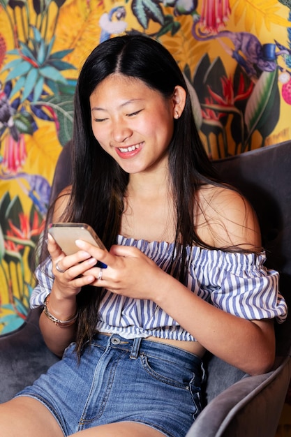 Mulher usando um telefone celular sentado em uma poltrona