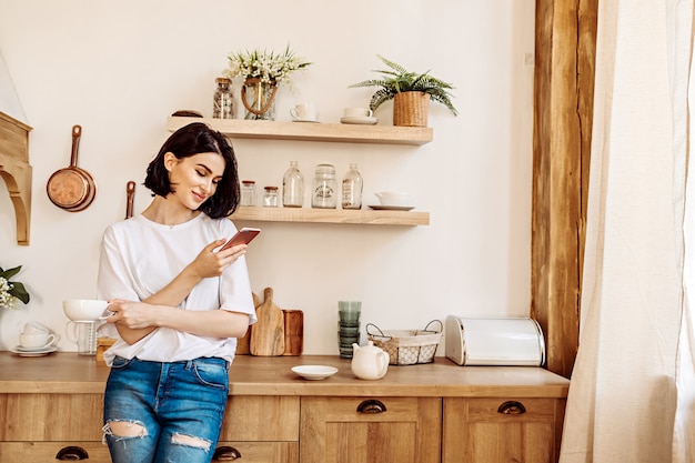 Mulher usando um telefone na cozinha