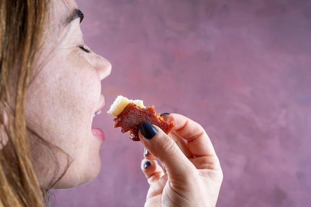 Mulher vai morder fatias de goiabada e queijo