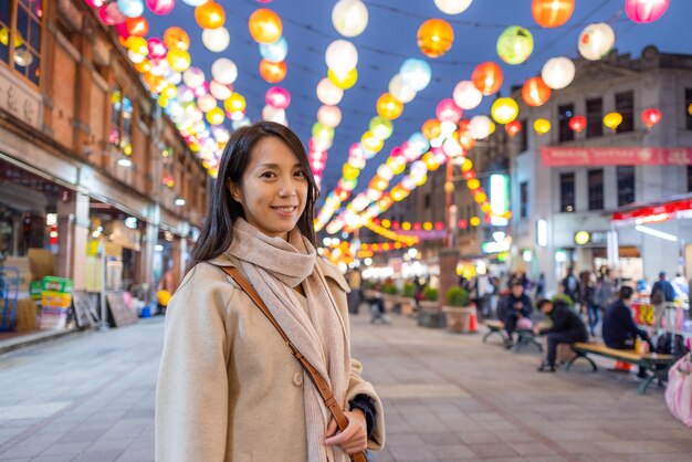 Mulher vai para a rua Dihua em Taipei à noite no período do Ano Novo Chinês