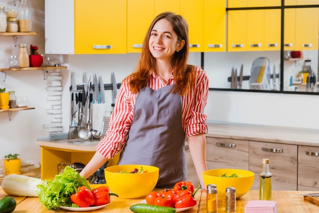 Mulher vegetariana feliz sorridente na cozinha