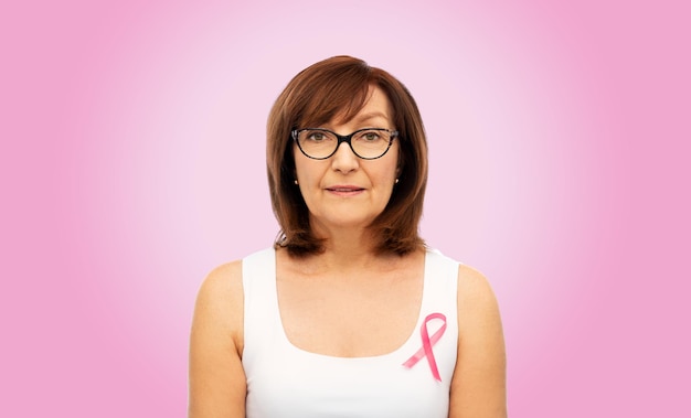 mulher velha com fita rosa de conscientização sobre câncer de mama
