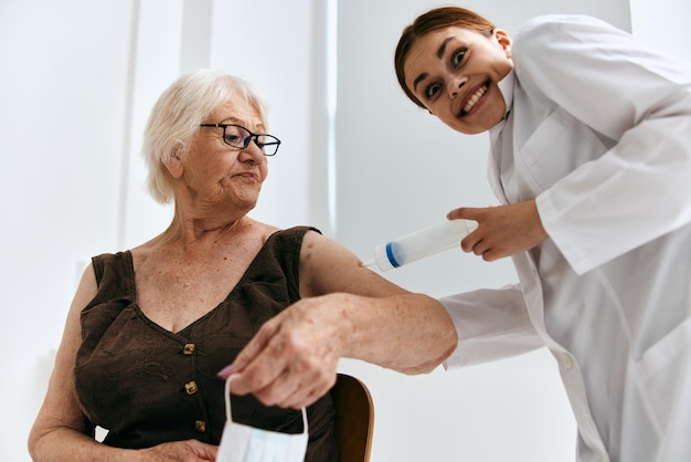 Mulher velha na consulta do médico grande diversão de seringa