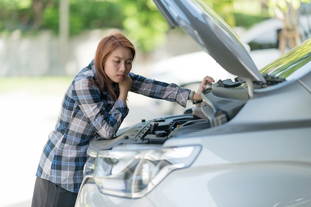 Mulher verificando o nível de óleo em um carro, trocar o carro de óleo