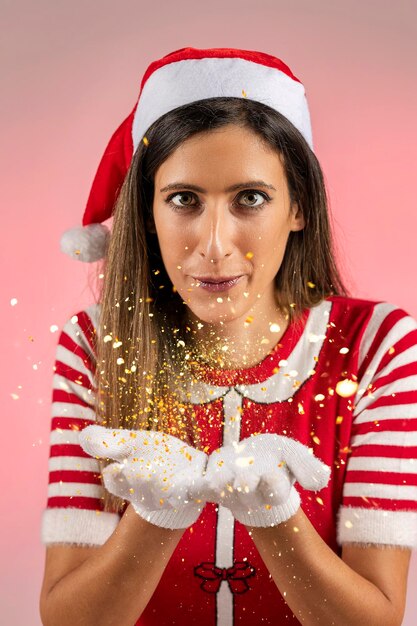 Foto mulher vermelha de papai noel a soprar.