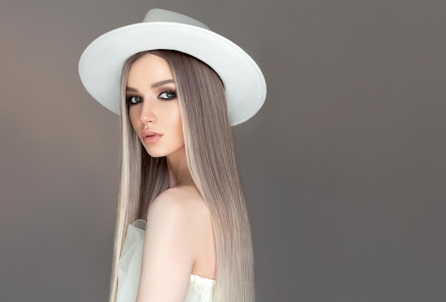 Foto mulher vestida com um chapéu estilo cowboy cabelo liso tingido em tons de cinza pálido com mechas loiras