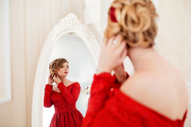 Mulher vestida de vestido vermelho olhando no espelho