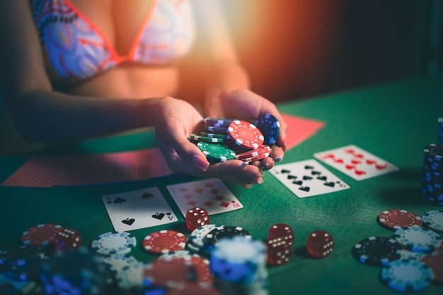 Mulher vestindo biquíni ou croupier embaralha cartas de pôquer em um cassino no fundo de uma mulher tableasain segurando fichas Conceito de jogo de pôquer de pôquer de cassino