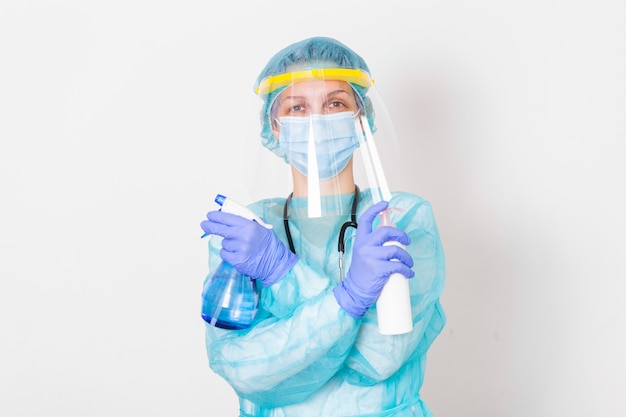 Mulher vestindo luvas, traje de proteção contra riscos biológicos, escudo facial e máscara com garrafa desinfetante para as mãos e gel de desinfecção. vírus corona ou proteção Covid-19.
