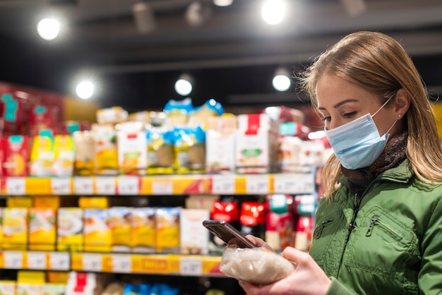 Foto mulher vestindo máscara facial no supermercado