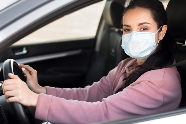 Foto mulher vestindo máscara médica no carro