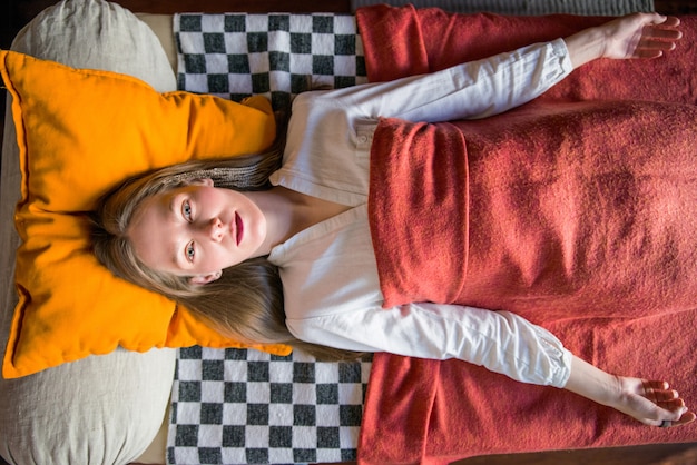 Mulher vestindo roupão deitado na mesa de massagem, preparando-se para o tratamento de spa