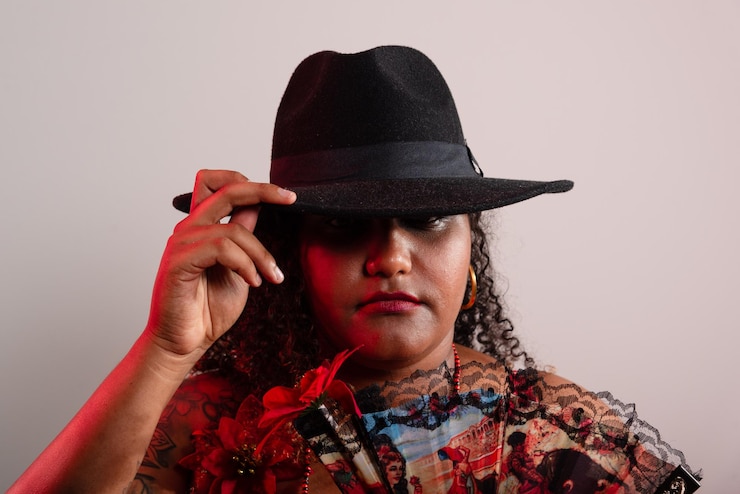 Foto mulher vestindo roupas tradicionais de ciganos sentada posando para uma foto em um estúdio