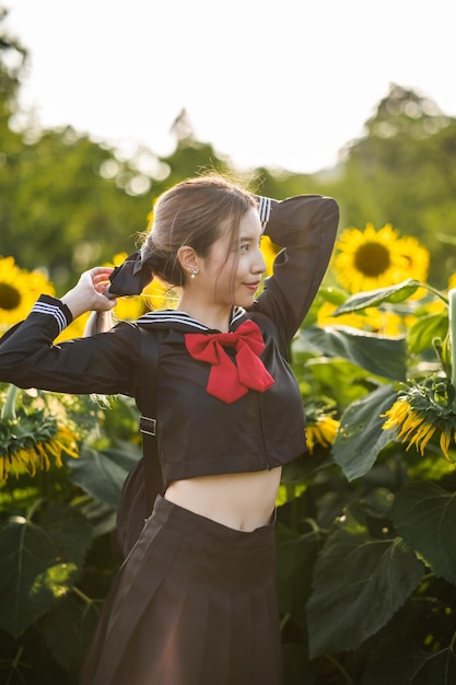 Mulher vestindo uniforme escolar japonês cosplay no jardim de girassol ao ar livre