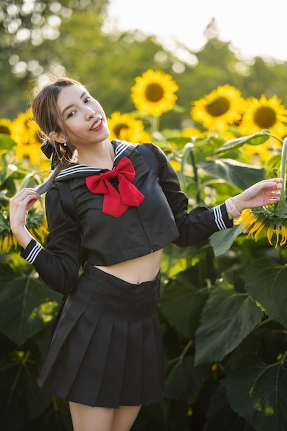 Mulher vestindo uniforme escolar japonês cosplay no jardim de girassol ao ar livre