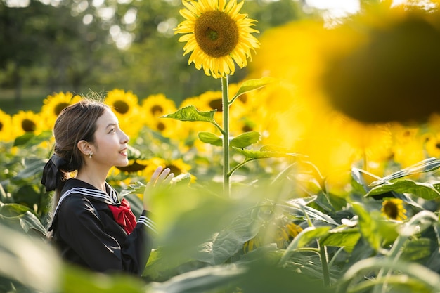 Mulher vestindo uniforme escolar japonês cosplay no jardim de girassol ao ar livre