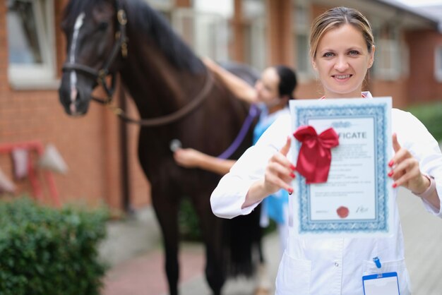 Mulher veterinária está segurando atestado médico em cavalo de fundo