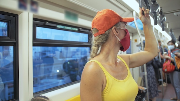 Mulher viaja passeio caucasiano no trem aéreo com máscara médica protetora Menina turista no trem aéreo com respirador Máscara de pessoas