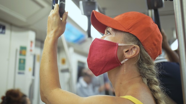Mulher viaja passeio caucasiano no trem aéreo com máscara médica protetora Menina turista no trem aéreo com respirador Máscara de pessoas