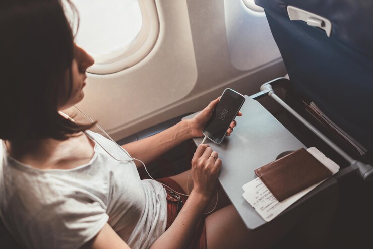 Foto mulher viajando de avião garota com um telefone nas mãos sentada no avião