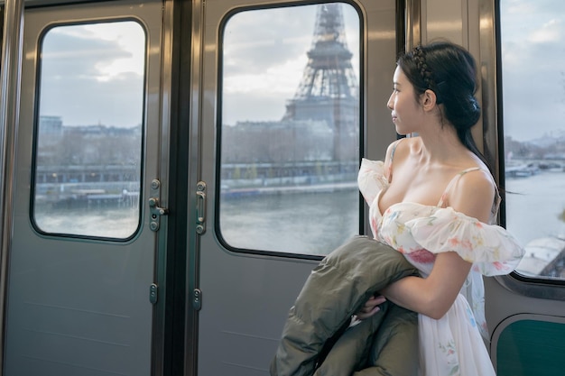 Mulher viajando em um trem e olhando pela janela para a torre Eiffel