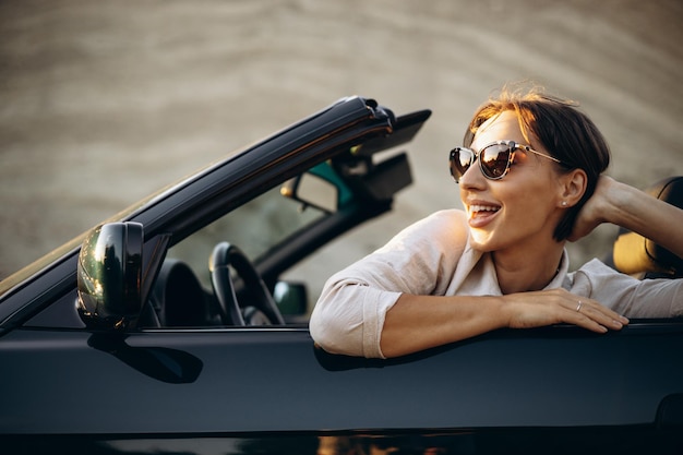 Mulher viajando por seu carro cabriolet