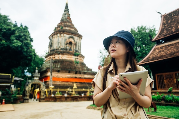 Mulher viajante asiática com uma tábua no templo ok moli na província de Chiang Mai, na Tailândia