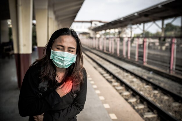 Mulher viajante asiática usa máscara para proteger coronavírusMulher tailandesa usando máscara facial, proteção respiratória e filtro de partículas pm25