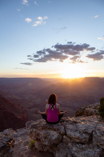 Mulher viajante aventureira fazendo meditação na paisagem americana da montanha rochosa do deserto